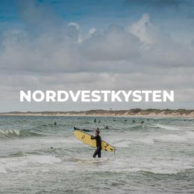 Surfer i vandet ved strand i Nordvestkysten